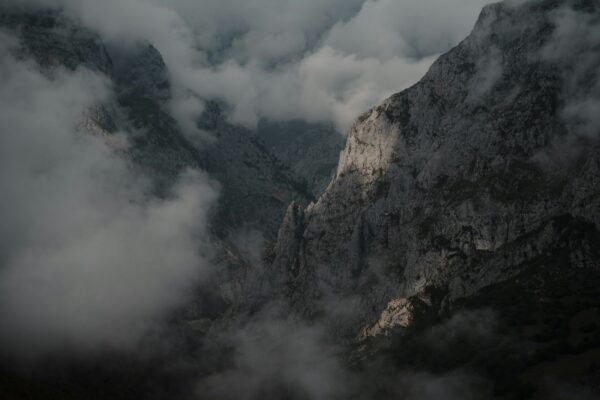 A view of a mountain with clouds in the sky