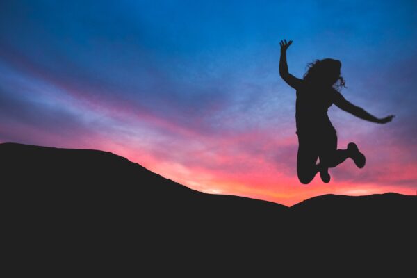 silhouette of person jumping during dawn