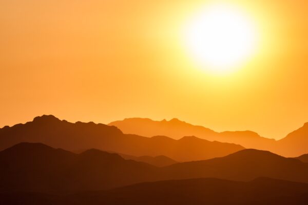 silhouette of mountains under orange sky