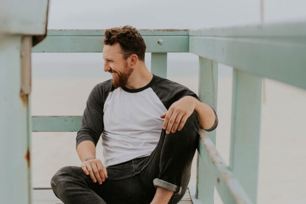 man smiling while sitting on floor during daytime