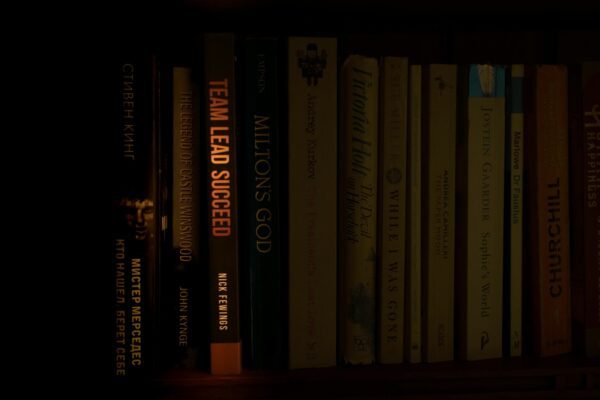 a bookshelf filled with lots of books in a dark room