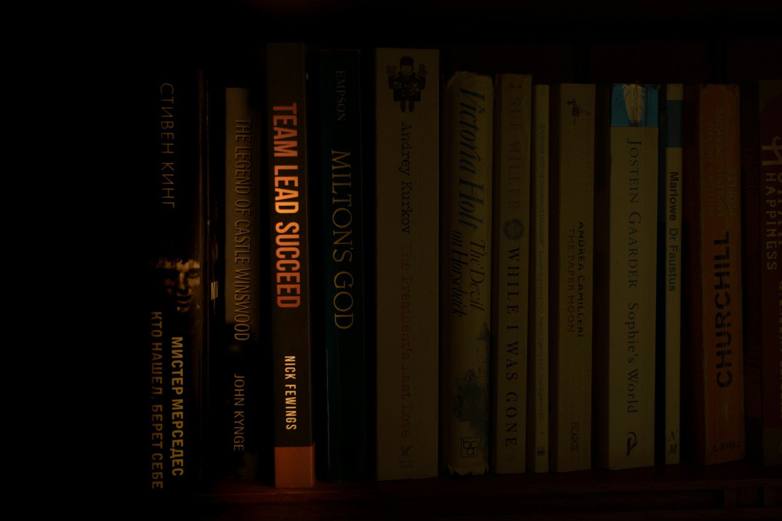 a bookshelf filled with lots of books in a dark room