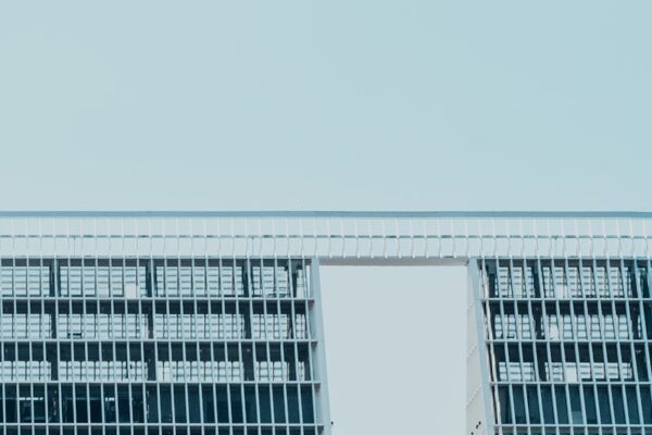 an airplane flying over a building with a sky background