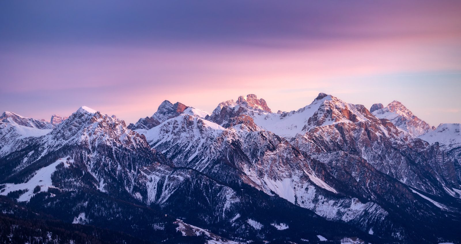 A mountain range with snow covered mountains in the background