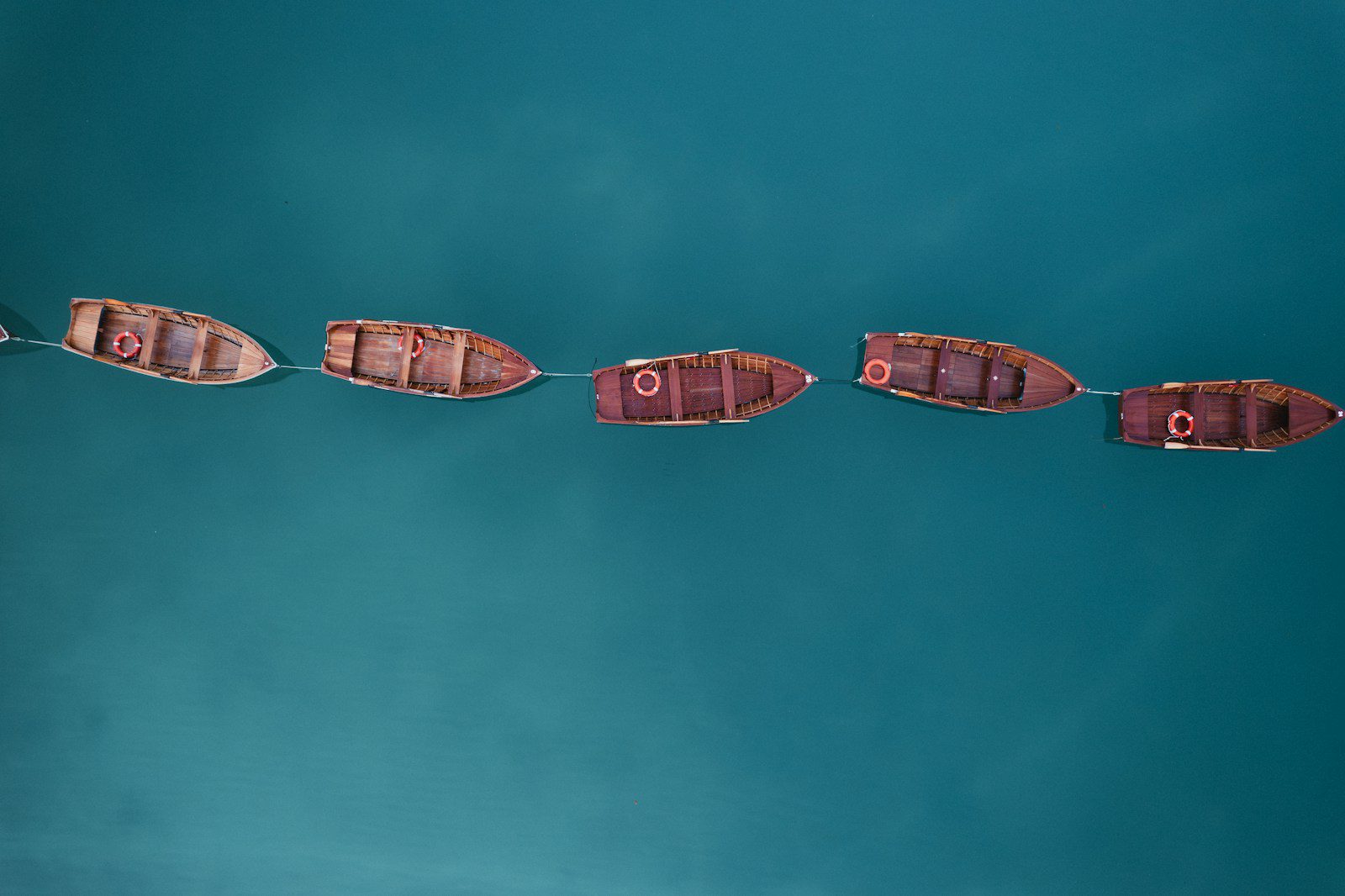 A row of boats floating on top of a body of water